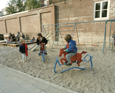 800794 Afbeelding van enkele spelende kinderen in de speelplaats, aangelegd op het binnenterrein van de voormalige ...